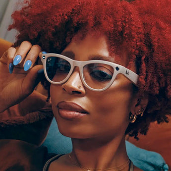Stylish woman wearing RAY-BAN META smart glasses with white frames and blue-tinted lenses relaxing indoors